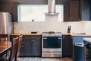 A modern kitchen with a wooden countertop, cupboards and kitchen appliances