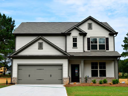Facade of a two-storey house with a garage and front yard