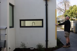 Registered building inspector in Melbourne examining the exterior structure and walls of a residential property