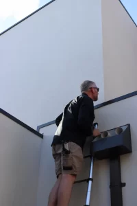 Registered building inspector in Melbourne performing exterior wall inspection on residential property