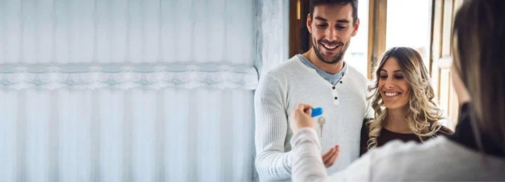 agent handing over the house key to couple