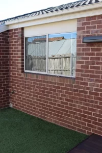 Brick veneer wall with window and drainage points inspected for structural and moisture issues in Casey
