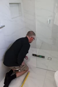 Inspector checking shower floor level during Melbourne pre-handover inspection